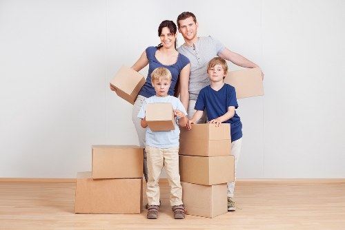 Packed moving boxes and furniture ready for transport in Mile End